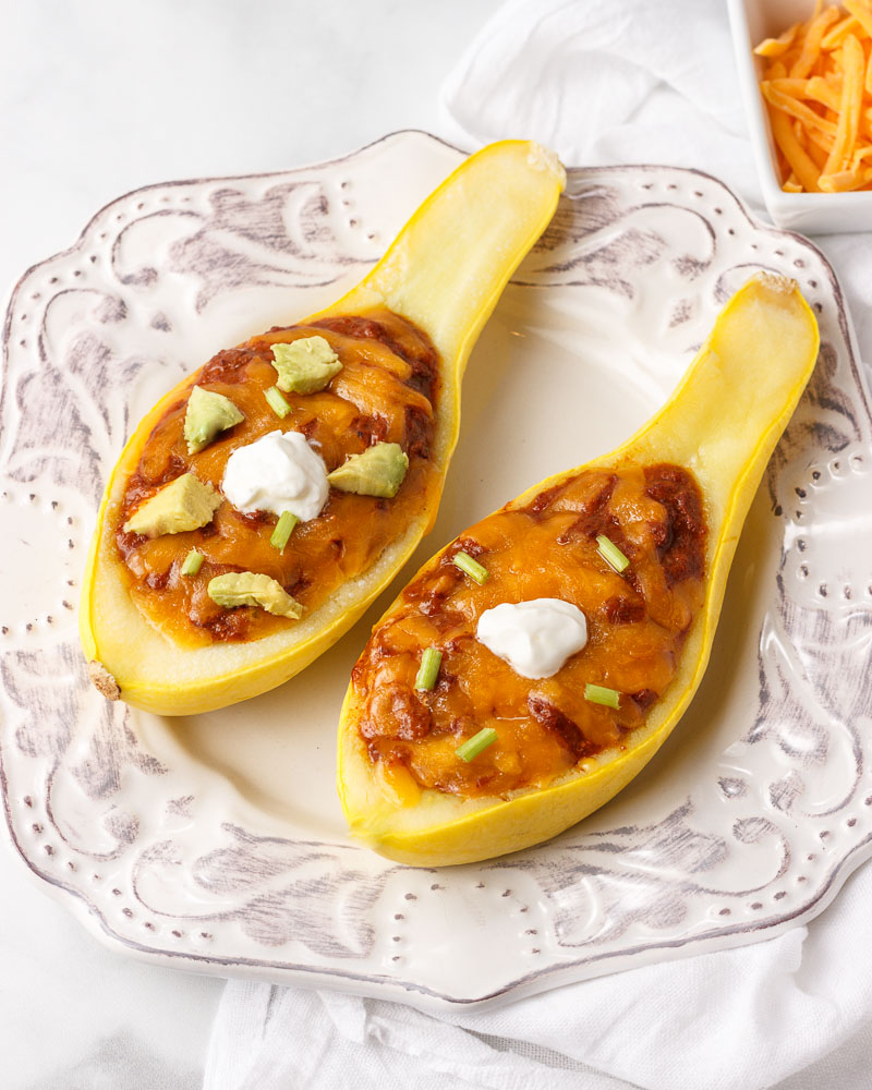 Two Yellow squash boats filled with chili.