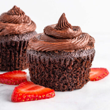 Two chocolate cupcakes with chocolate frosting.