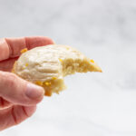 A keto lemon cookie with a bite taken out of it.