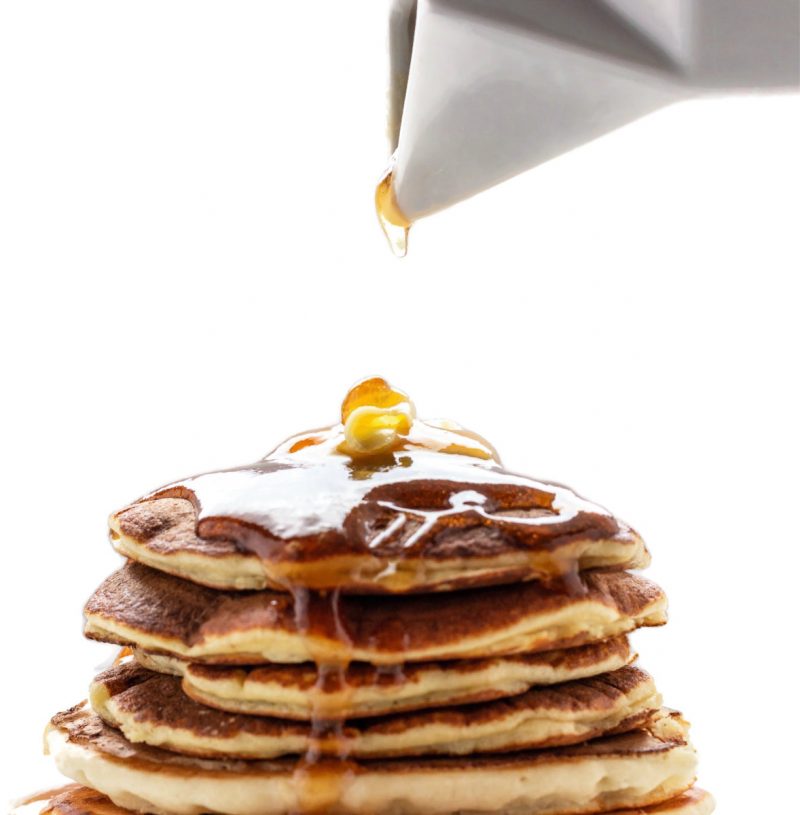 A keto pancake stack with a drop of syrup coming down on them.