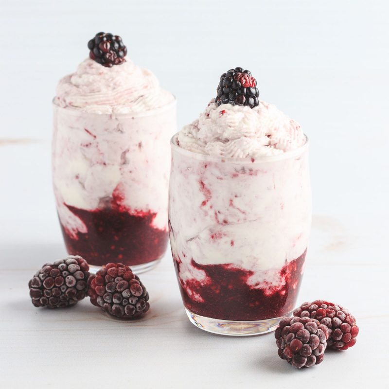 A fruit and cream dessert with blackberries.