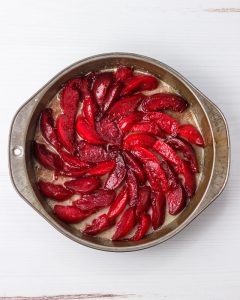 Step 2. Arranging plums in the pan.