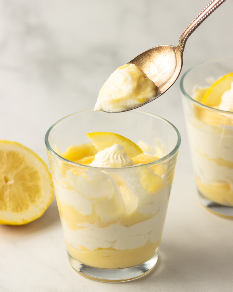 a spoonfull of a lemon cream parfait in a glass.