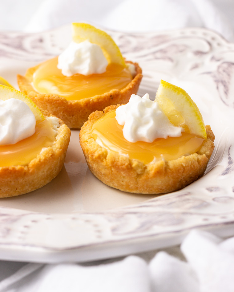 Three lemon supreme tarts with whipped cream.