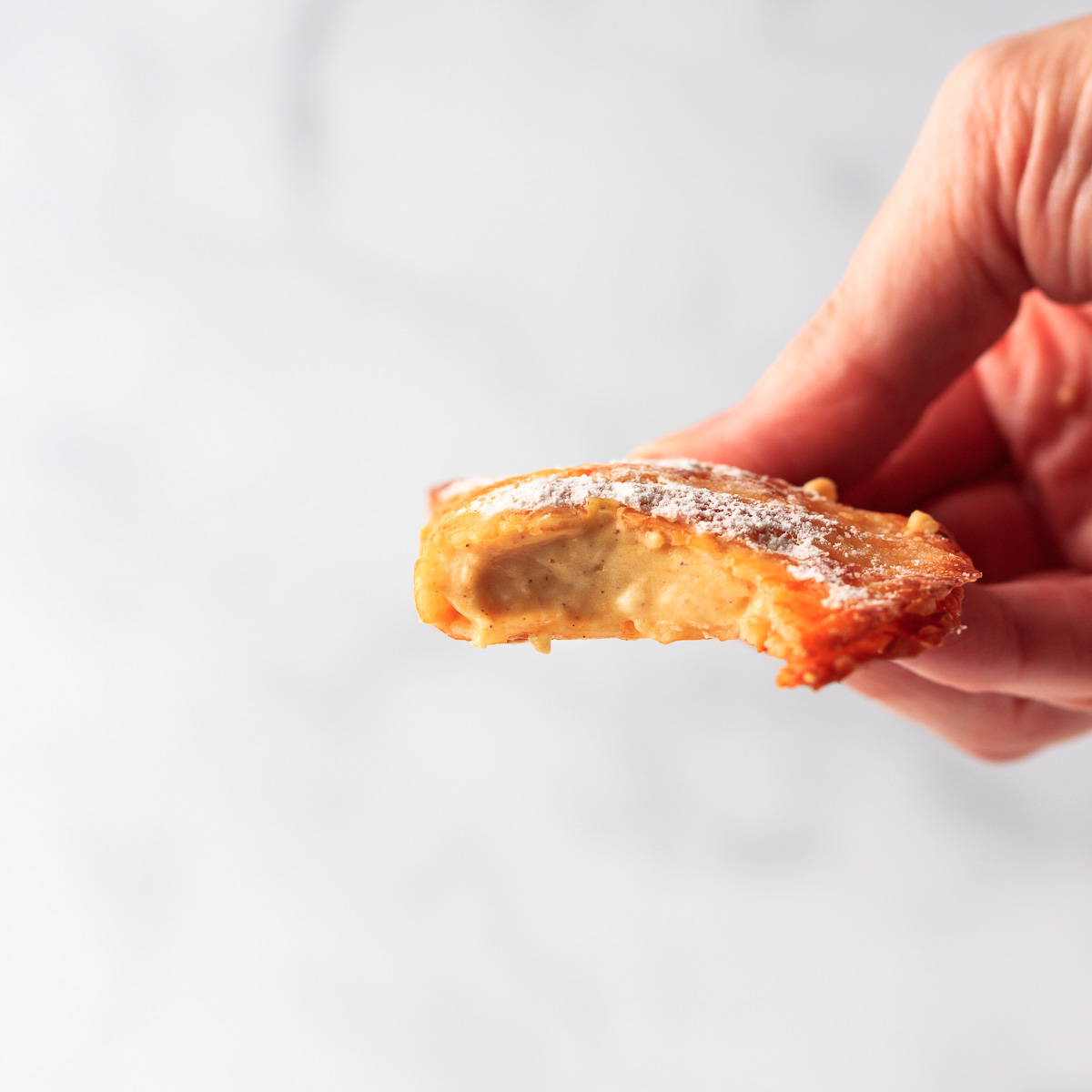 Pumpkin turnover with a bite out of it.