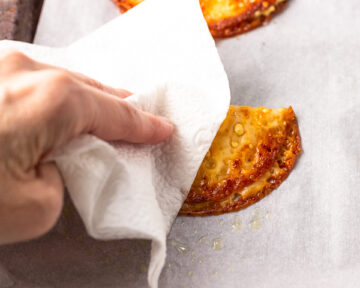 Gently blotting the turnover with a paper towel.