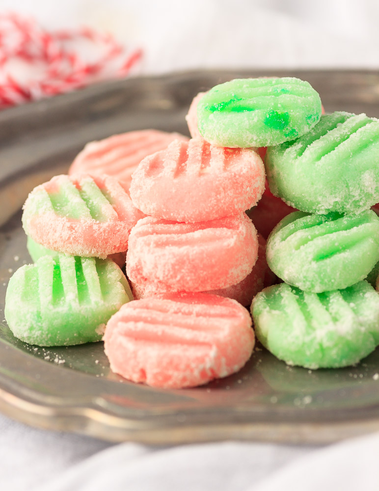 A metal plate with butter cream mints stacked on it.