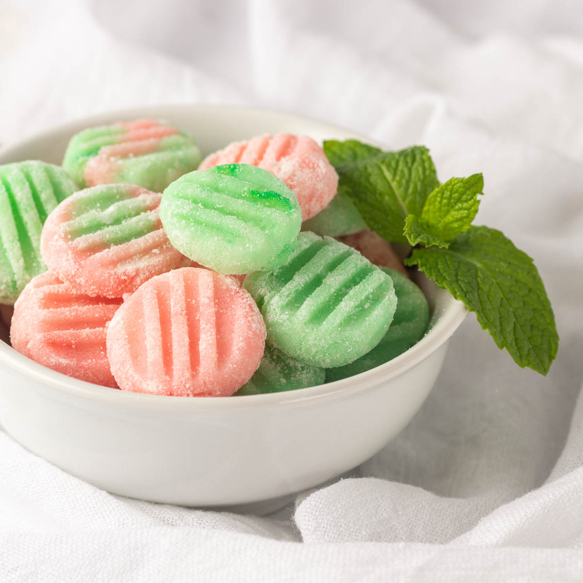 A bowl of green and pink soft mints.