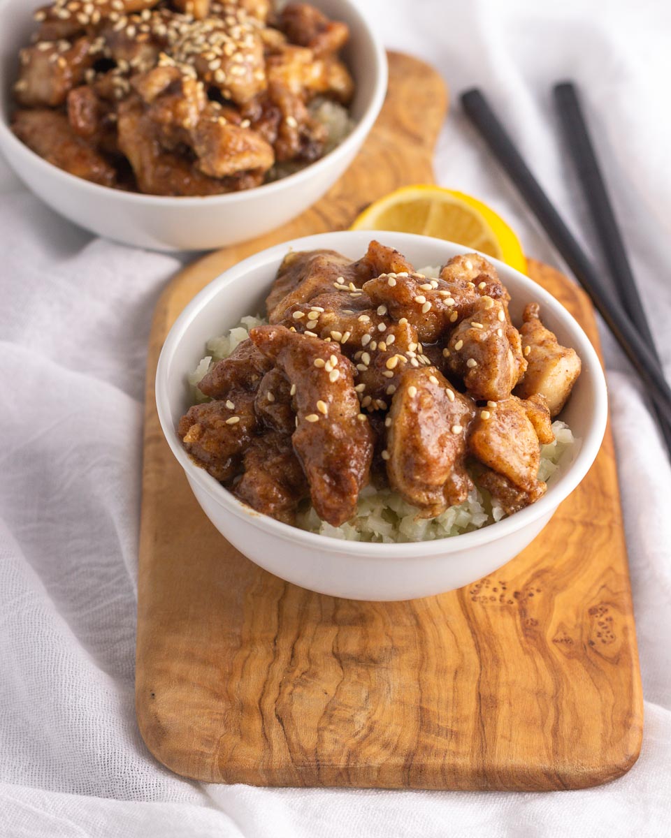  Two bowls on Chinese lemon chicken  with cauliflower rice.