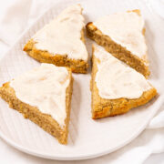 Four triangled shape pumpkin scones with icing.