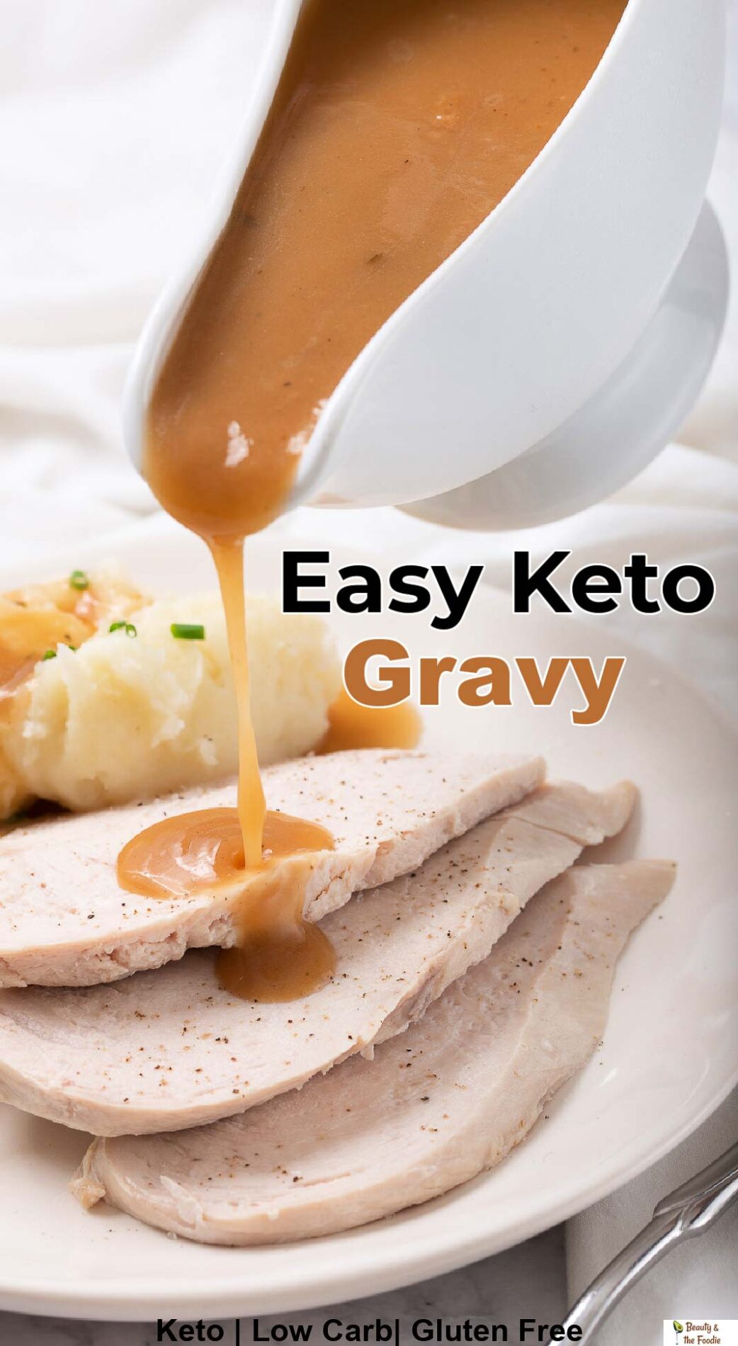 Pouring keto turkey gravy form a gravy boat over turkey breast and mashed cauliflower.