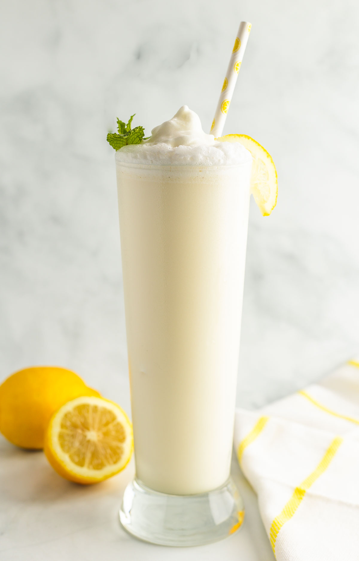 A glass of keto forsty lemon whip with lemon and mint garnish.