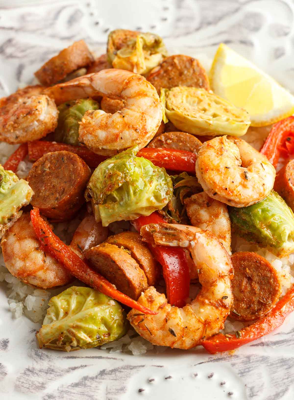 A plate of Cajun shrimp and sausage with veggies and cauliflower rice.
