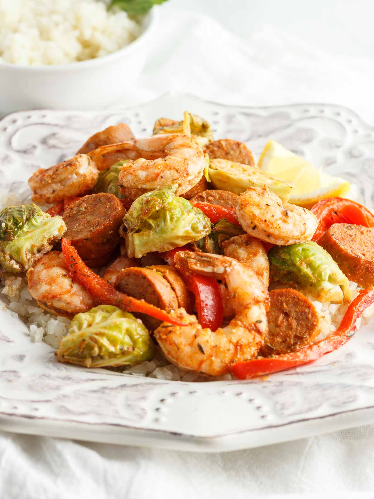 A  plate of Cajun shrimp and sausage with veggies and cauliflower rice.