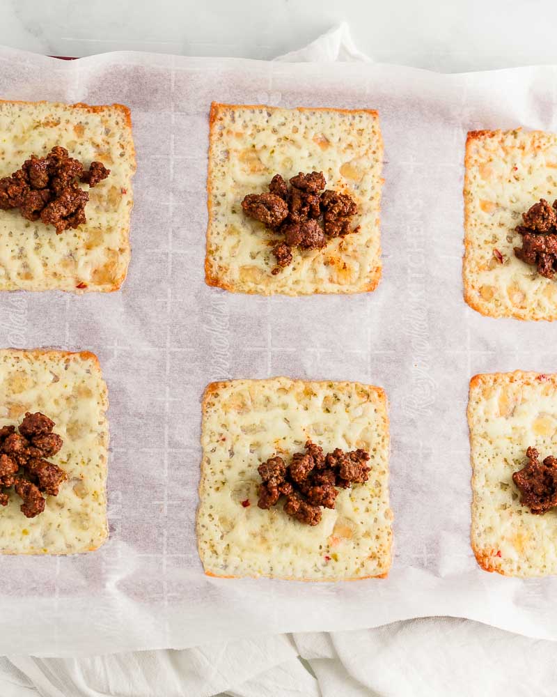 Adding taco meat to cheese slices.