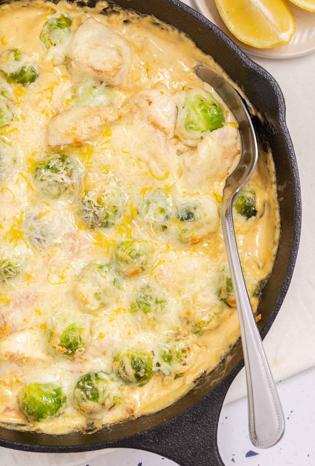 A skillet with chicken, bacon and Brussels sprouts in a creamy Parmesan sauce.