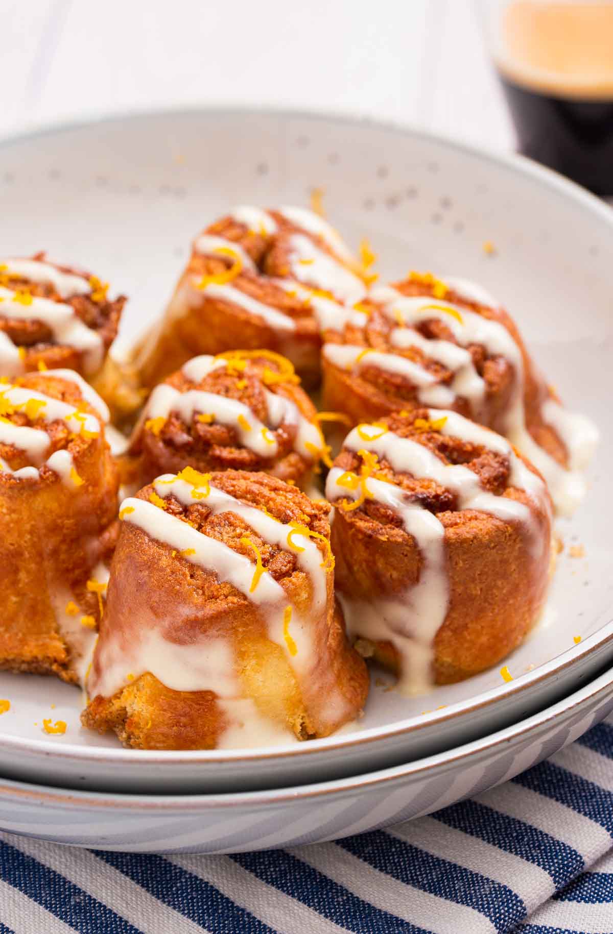 Low carb air fryer cinnamon rolls with a cream cheese glaze on a white plate.