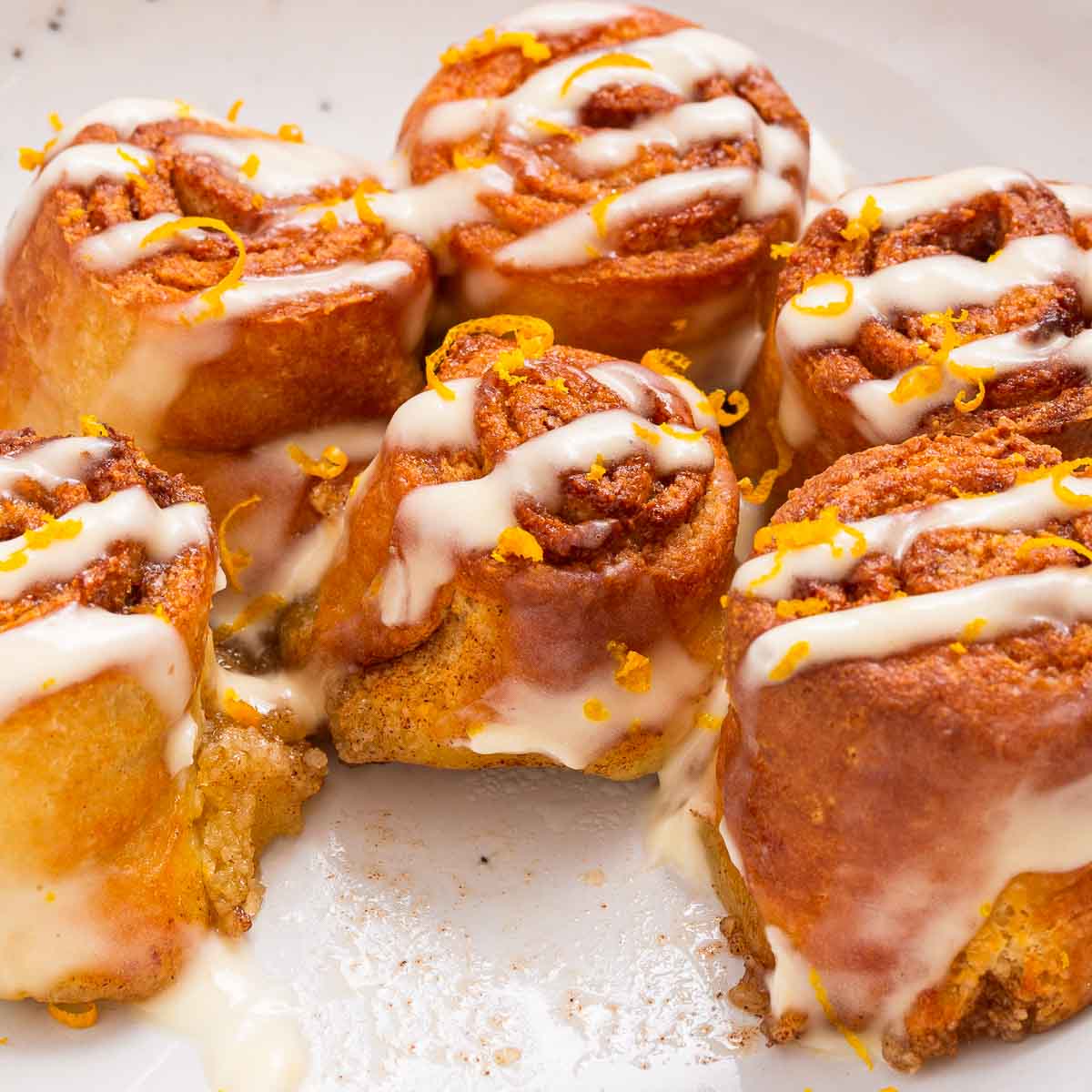 Low carb air fryer cinnamon rolls with a cream cheese glaze on a white plate