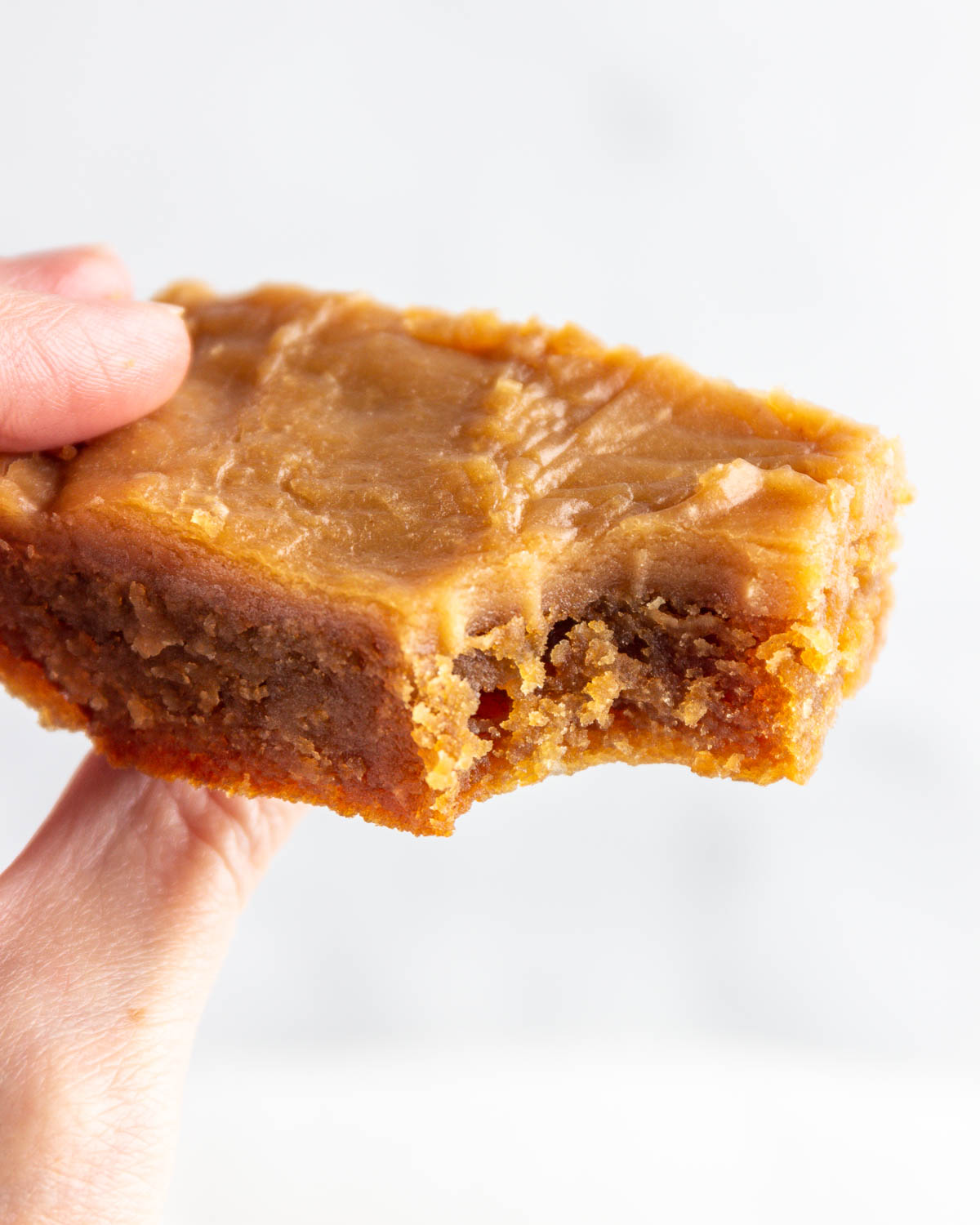 A keto iced peanut butter bar with a bite out of it.