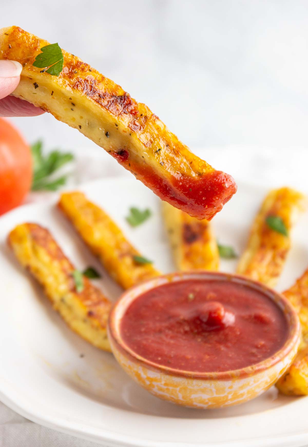 Dipping a pizza fried cheese stick into marinara sauce.