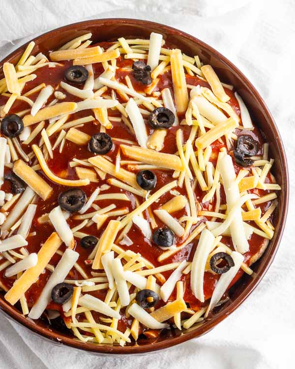 Adding cheese and olives.