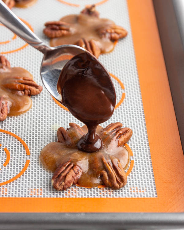Pouring melted chocolate over the caramel.