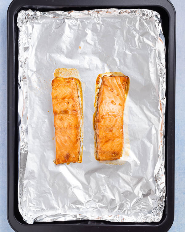 Removing salmon from the oven.