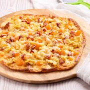 A breakfast pizz with scrambled eggs, bacon and cheese on a low-carb crust.