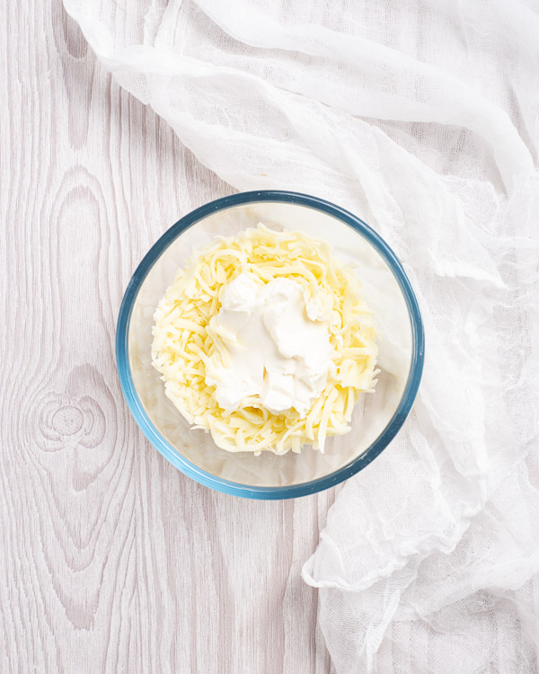 In a different medium bowl, combine shredded mozzarella and cubed cream cheese.