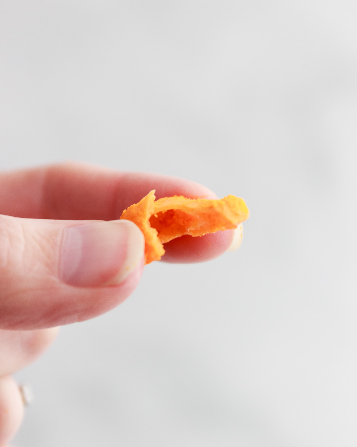 A keto cheese puff with a bite out of it.