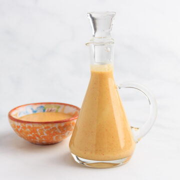 A small glass pitcher with keto honey mustard dressing inside.