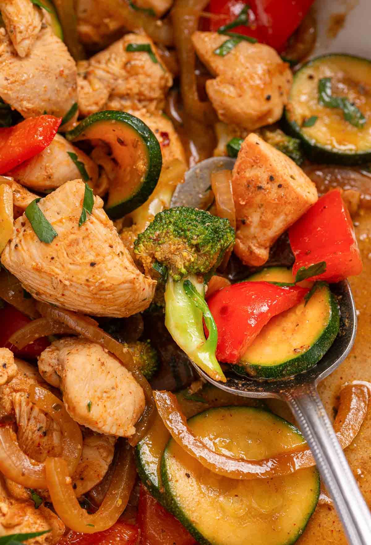 A skillet with chicken and stir-fried vegetables.