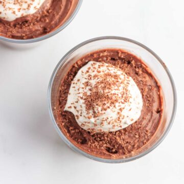 Two small glasses of keto chocolate coconut mousse with whipped cream.