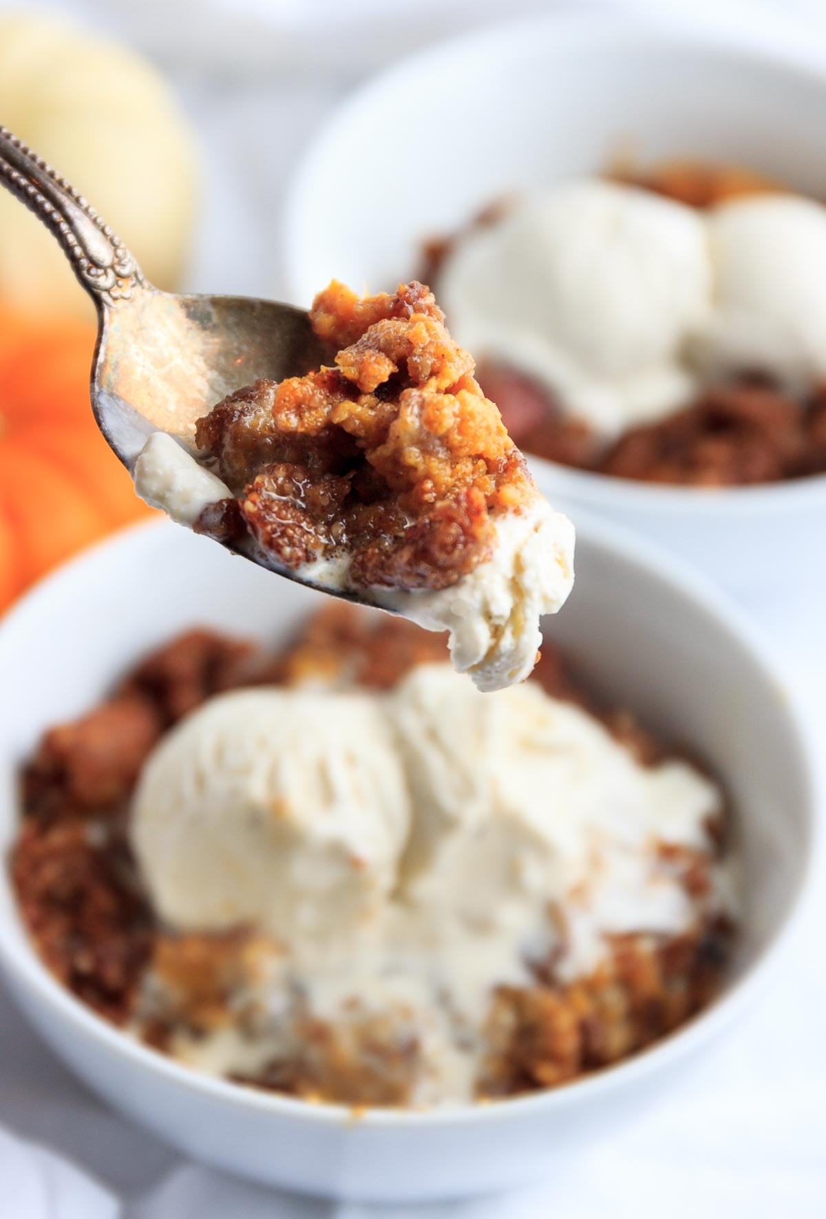 A spoonful of keto pumpkin crisp and vanilla ice cream.