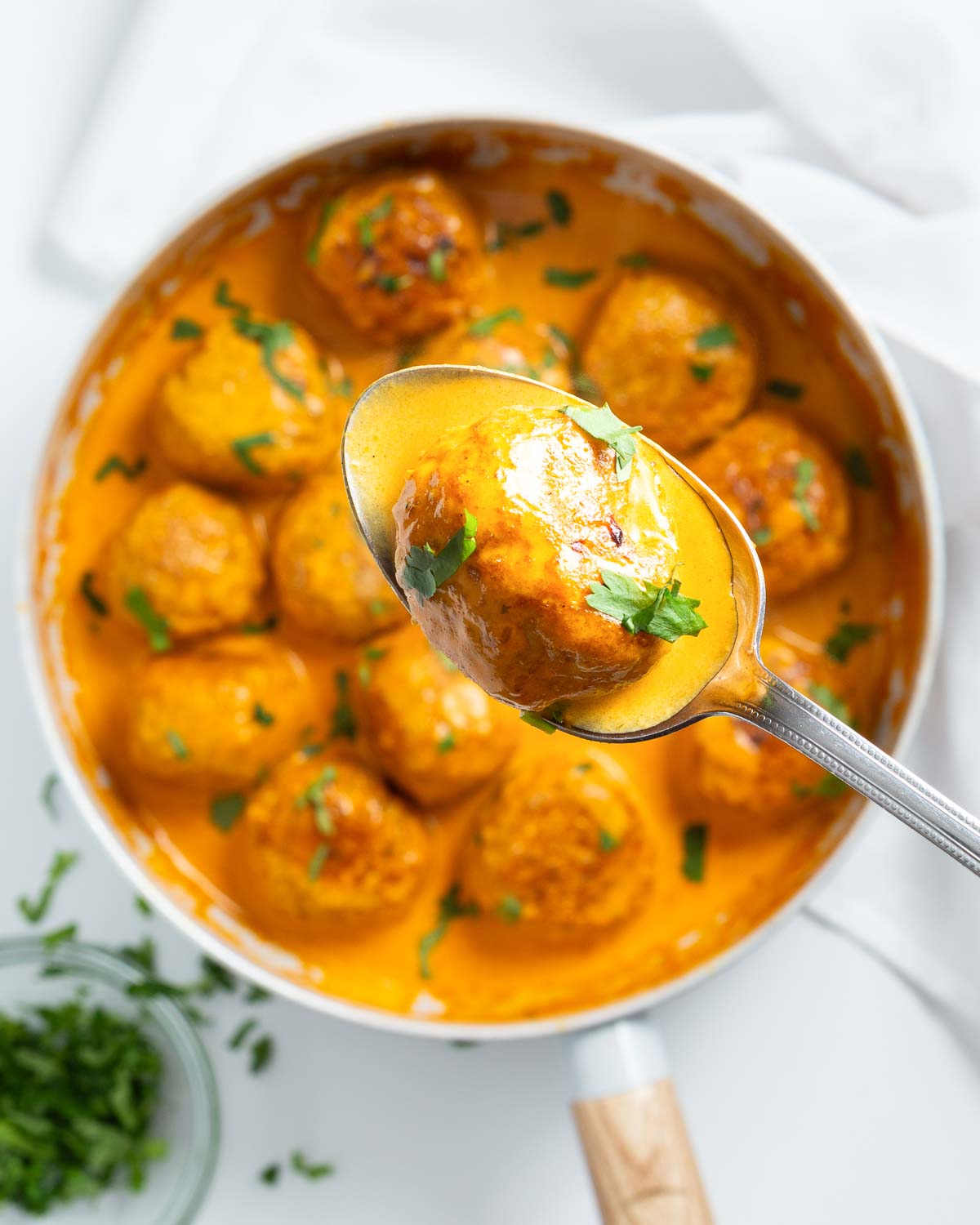 A skillet with keto butter chicken meatballs in creamy sauce.