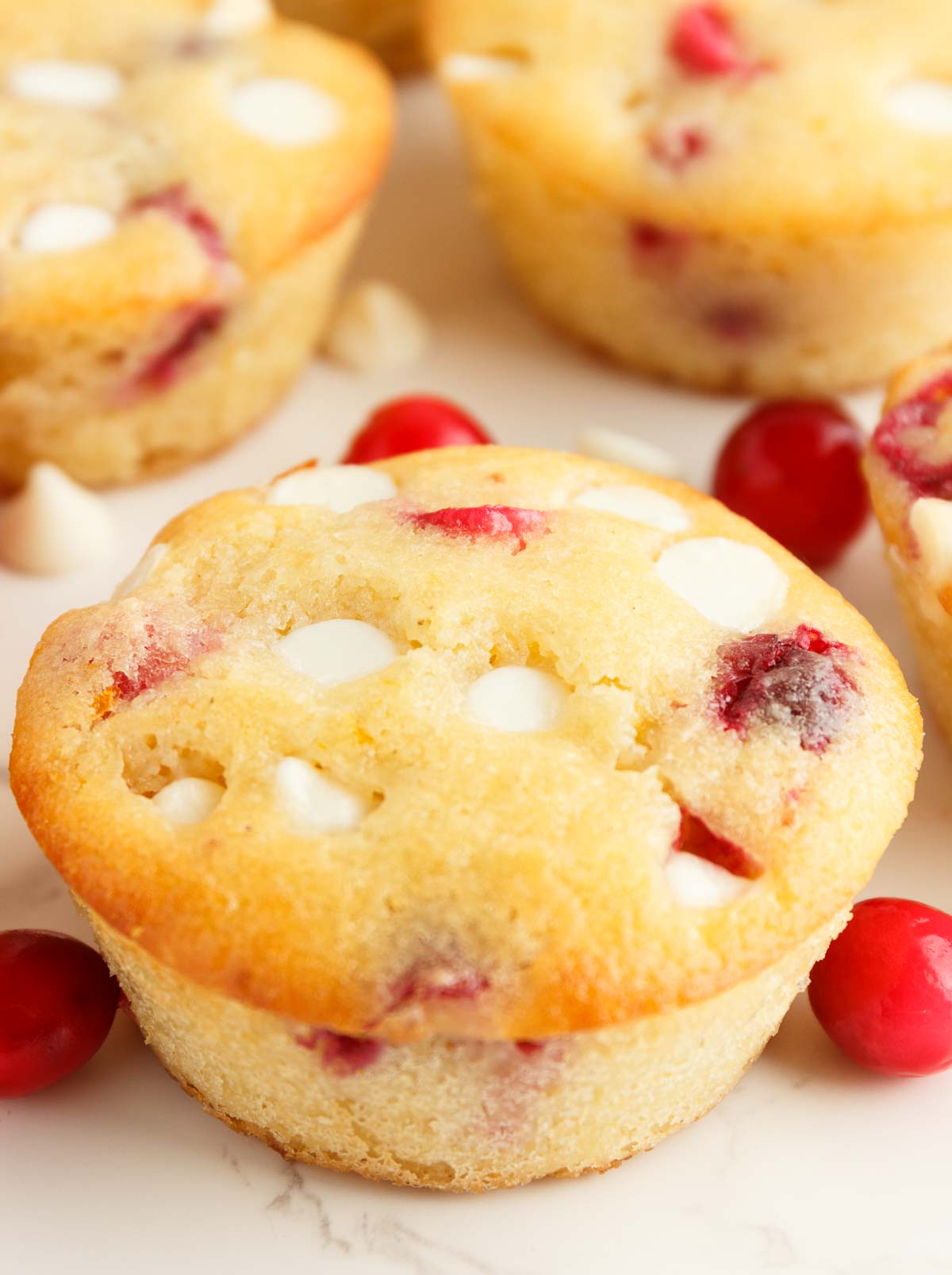 Keto Orange Cranberry Muffins with white chocolate chips and scattered cranberries.