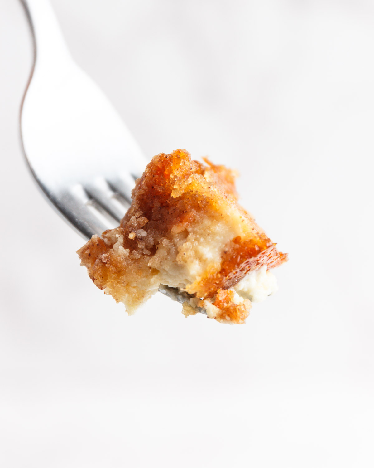 A bite of low carb carrot coffee cake with cream cheese on a fork.