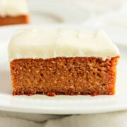 A square of pumpkin spice cake with creamy cheese frosting.