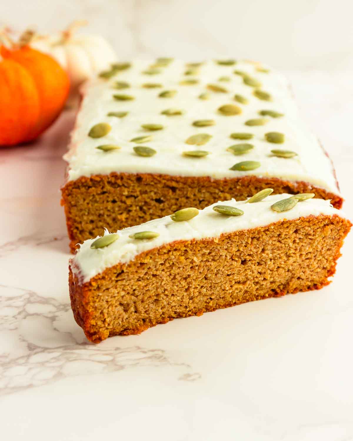 A frosted loaf of pumpkin bread with a cream cheese frosting.