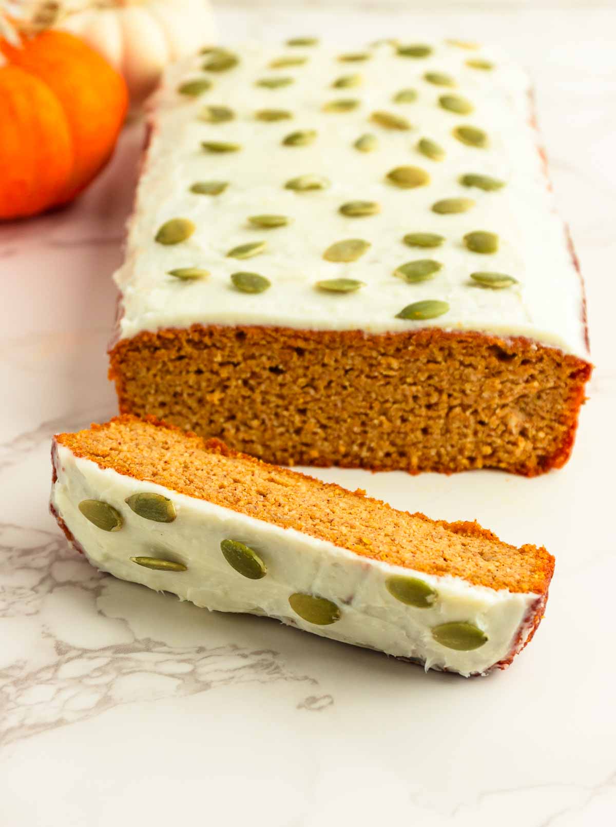 A frosted loaf of pumpkin bread with a cream cheese frosting.