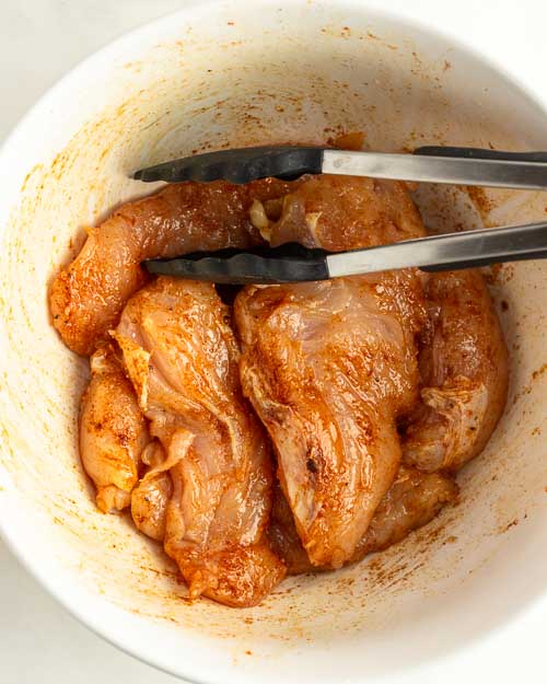 Tossing the chicken to coat.