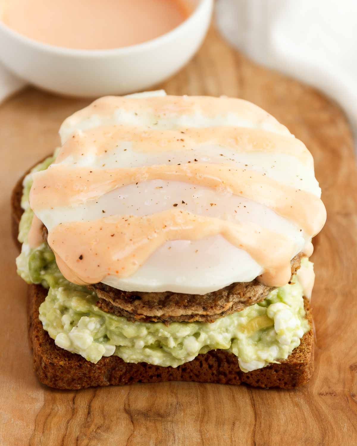 An egg, sausage, cottage cheese, and avocado, open-faced sandwich.