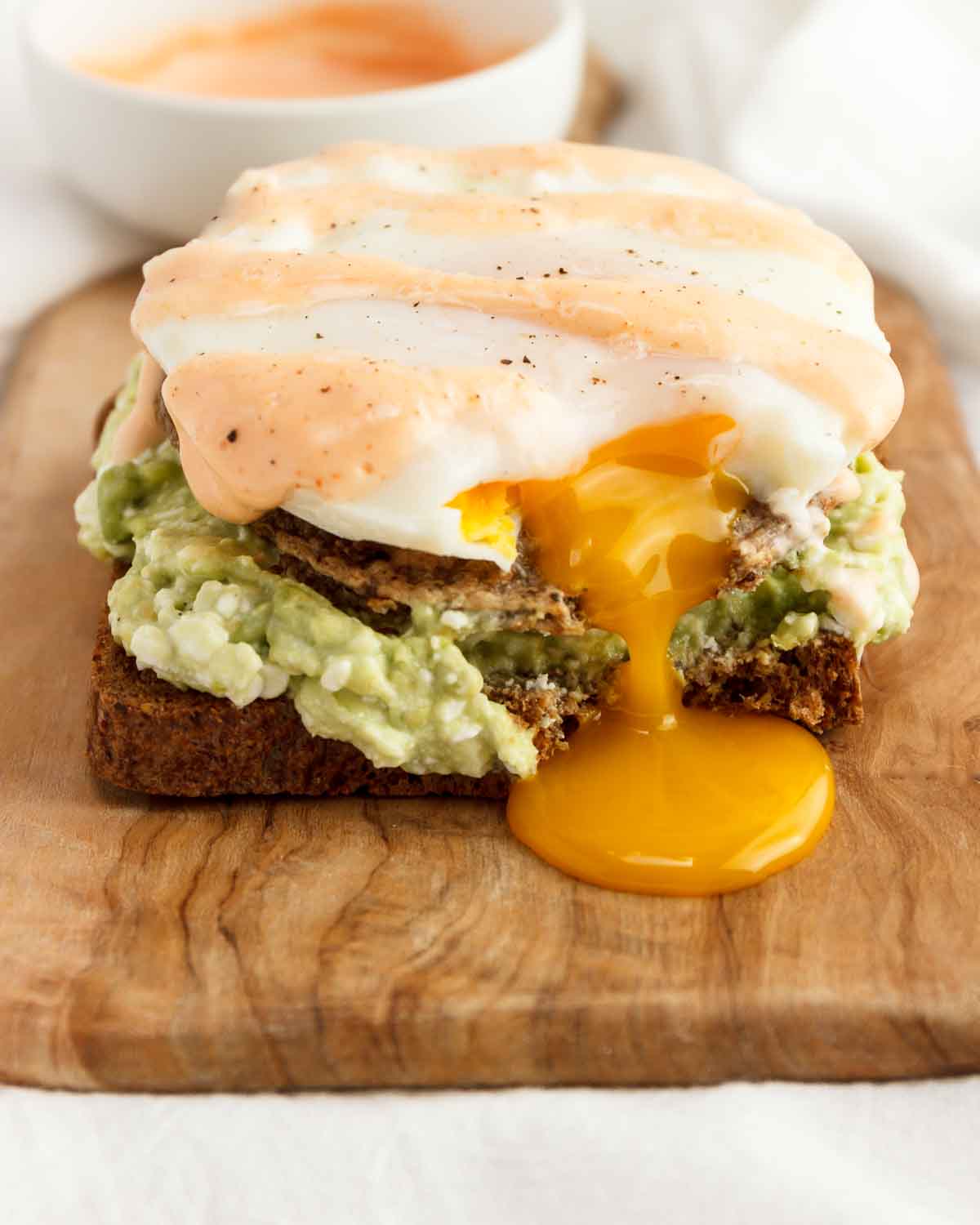 An egg, sausage, cottage cheese, and avocado, open-faced sandwich.