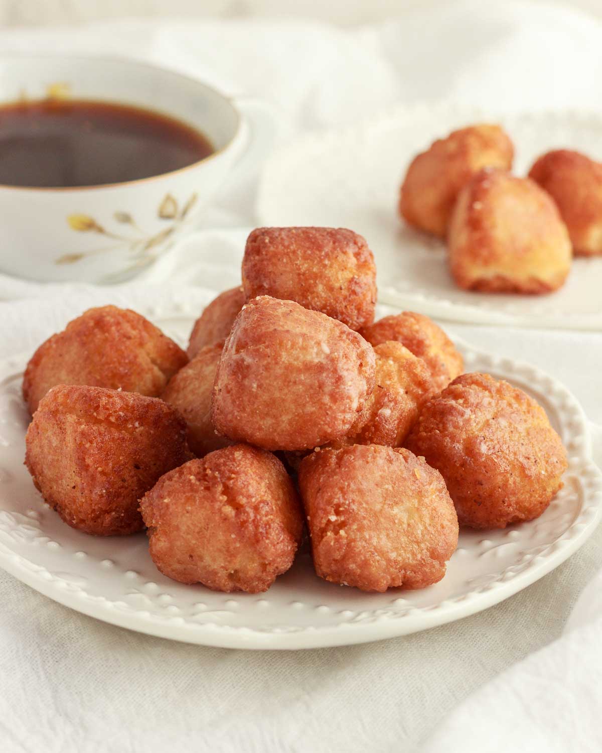 A plate with glazed, keto donut holes and a cup of coffee.