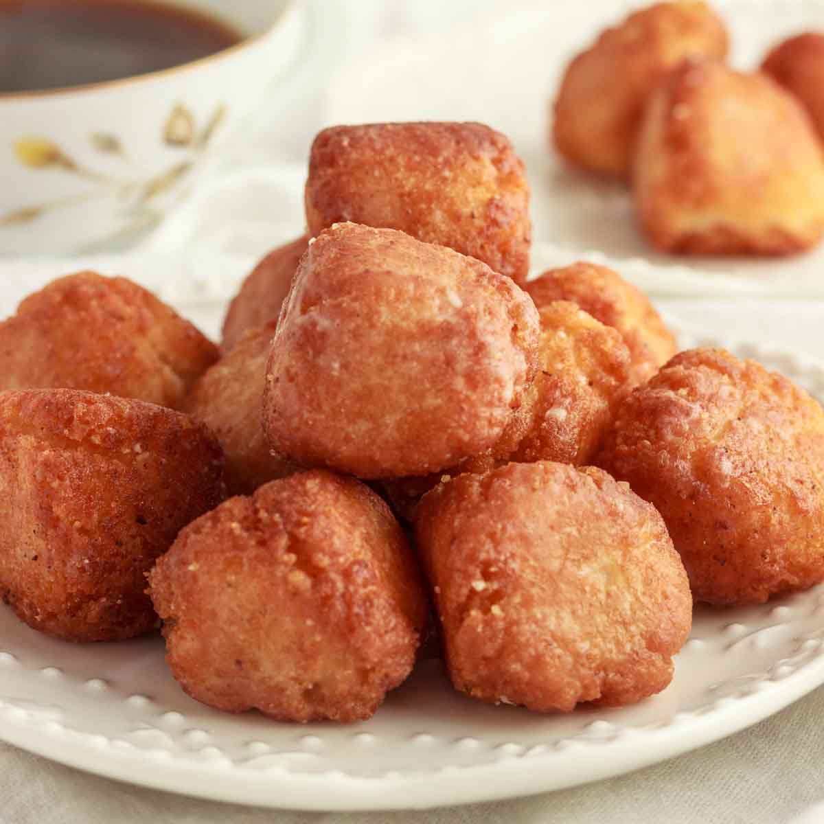 A plate with glazed, keto donut holes and a cup of coffee.