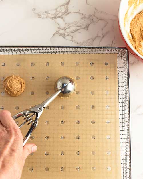 Scooping the dough onto the prepared basket or tray.