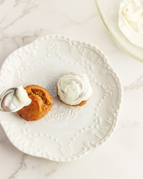 Frosting the keto pumpkin donut holes.