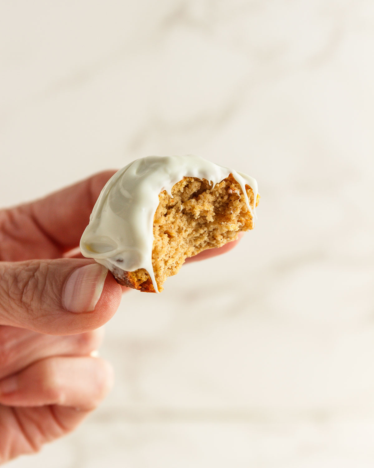 Keto Pumpkin Donut Hole with a bite in it held by a hand.
