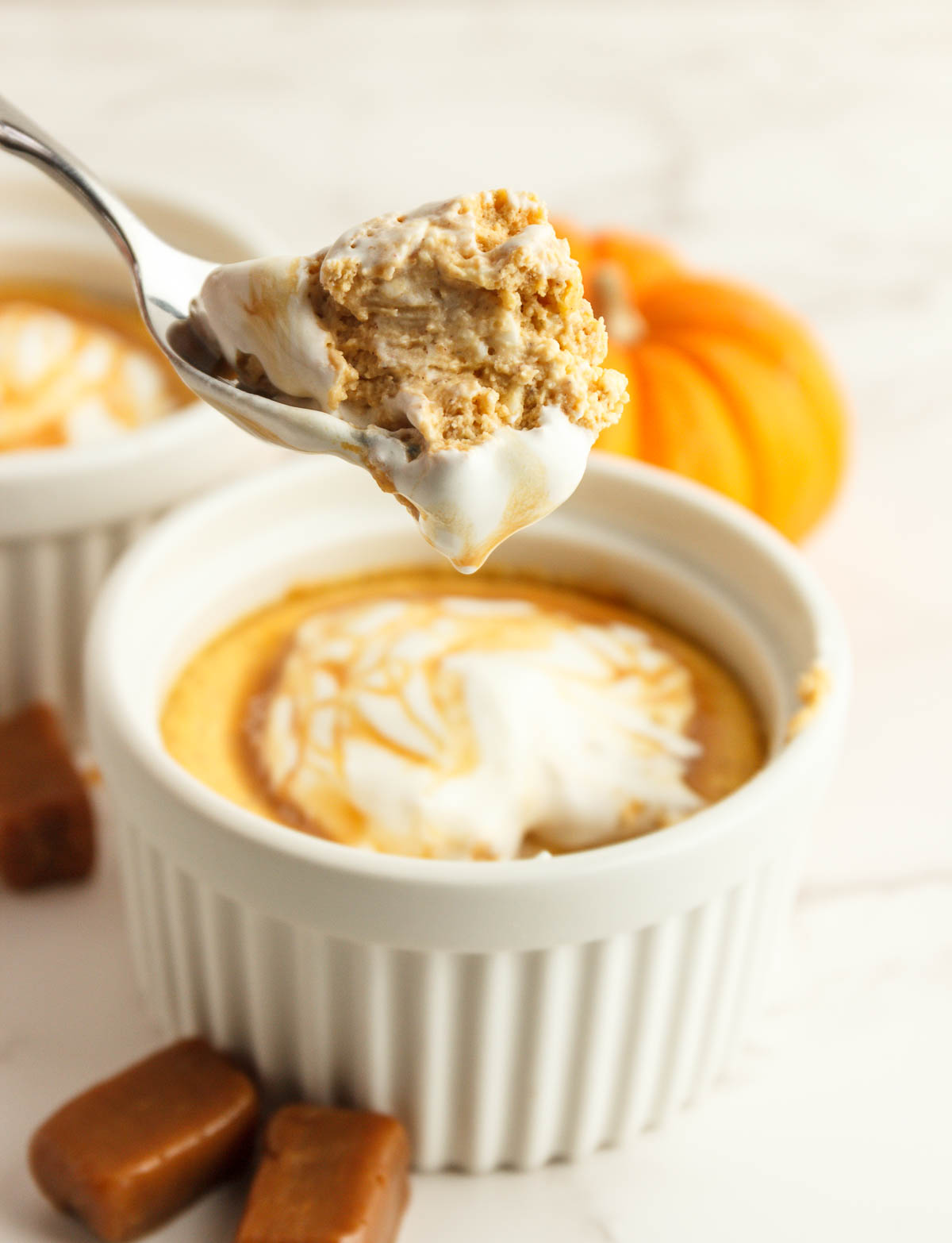 A bite on a spoon of keto mini pumpkin cheesecakes.