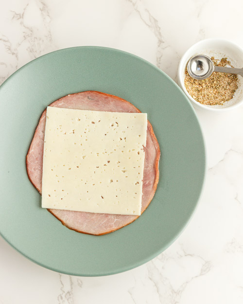 Adding the cheese to the ham.